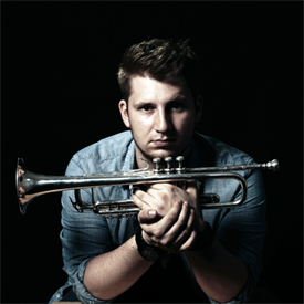 Dieses Bild zeigt Lukas Lindner. Er ist jung, trägt sein Haar kurz und ist dunkelhaarig. Er spielt Trompete in der HSD Big Band.